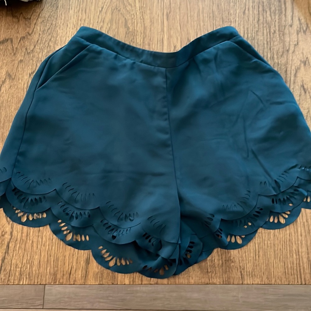 Teal shorts, functional pockets, laser cut detailing on hems